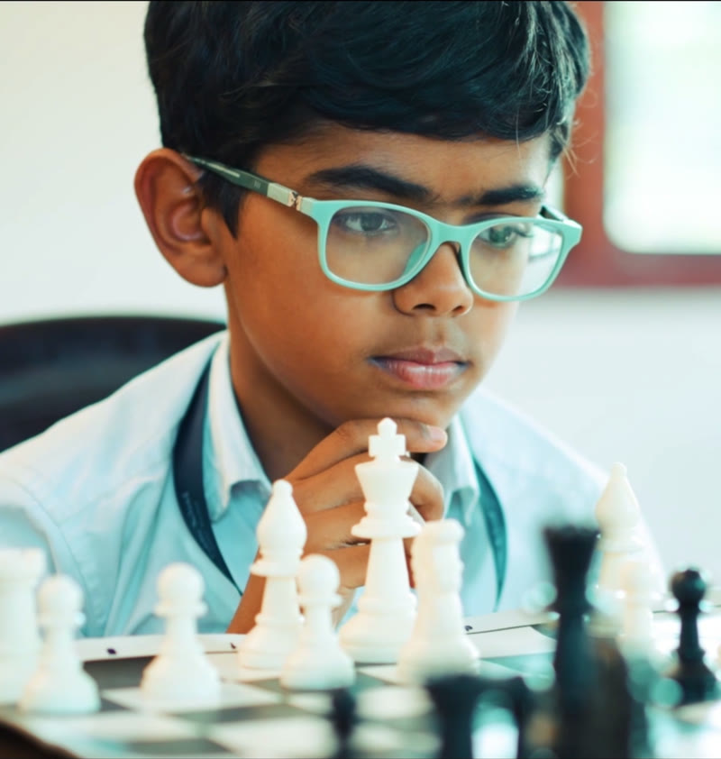 A student thinking over his next move at chess